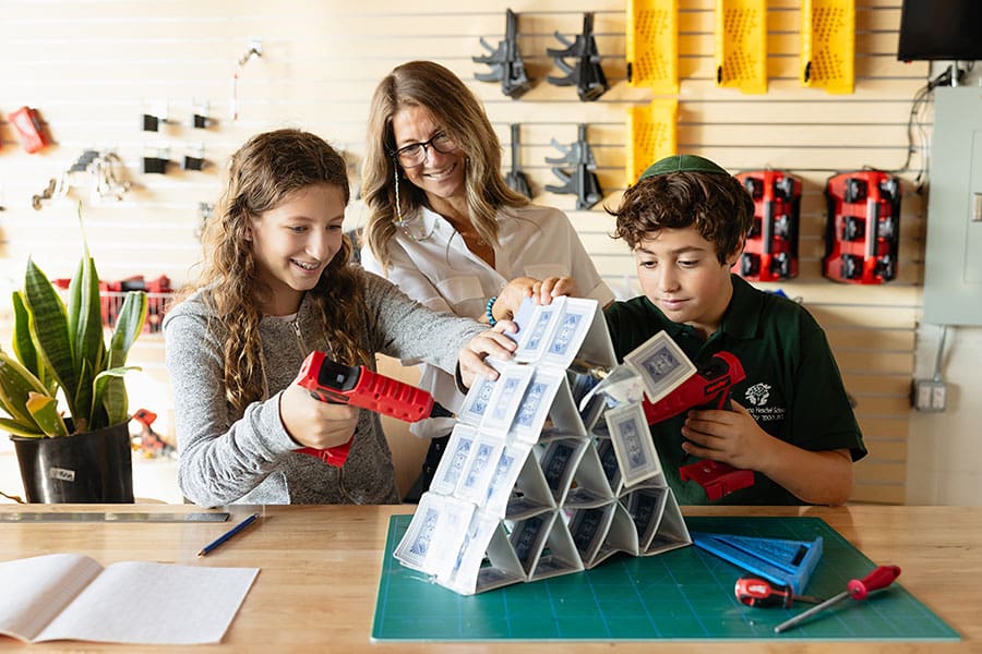 Student Academics - teacher and two students working on a project